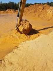 Pond being dug orange mud