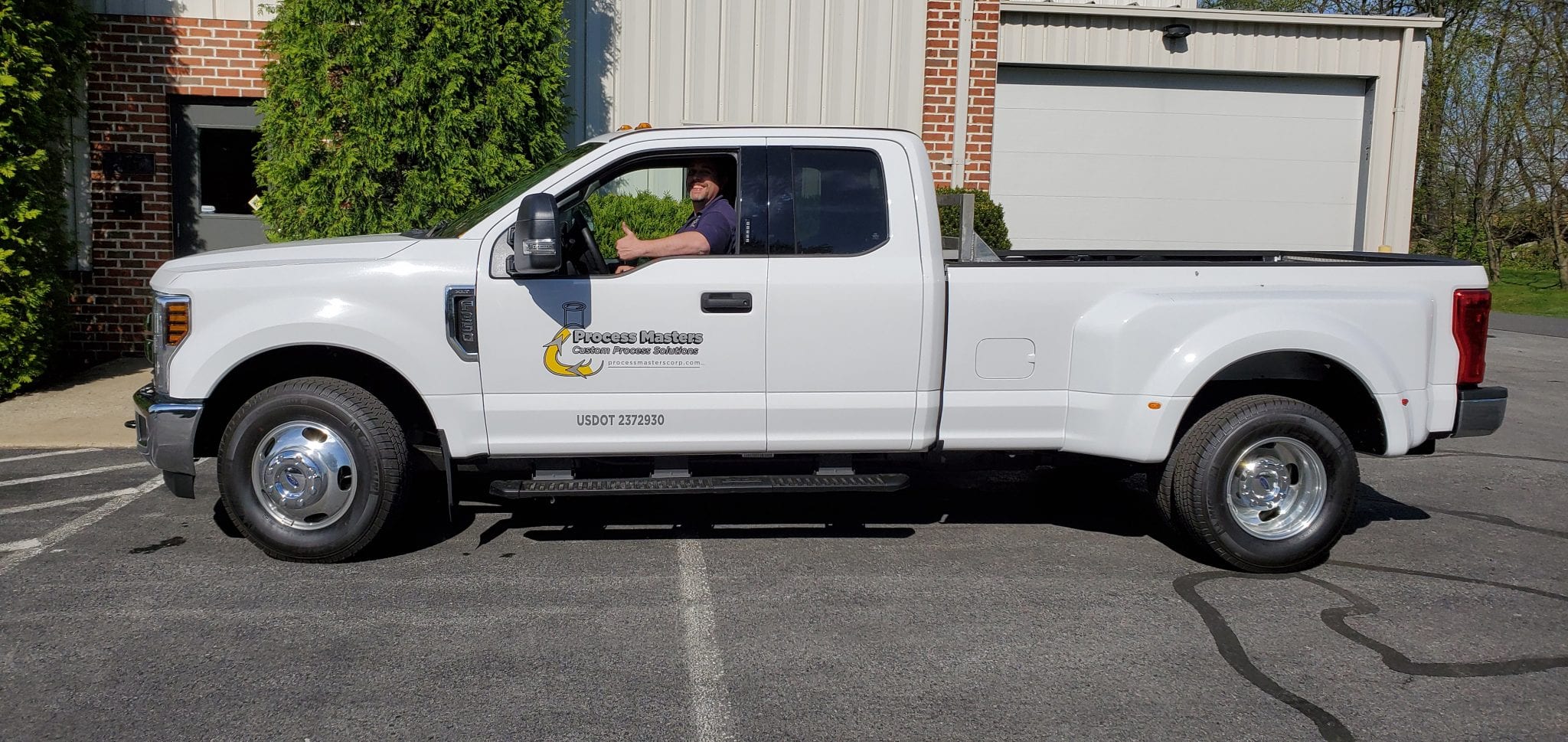 process-masters-truck white work truck with Process Masters logo, happy driver giving thumbs up to camera